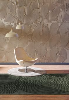 a white chair sitting on top of a rug in front of a wall mounted lamp