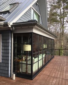 a house with a deck and glass windows