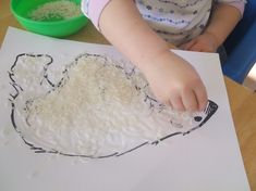 a young child is making a drawing with rice