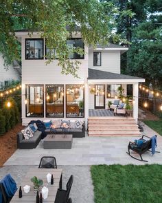 an outdoor patio is lit up with string lights and seating for the guests to sit on