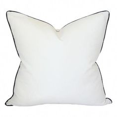 a white pillow with black piping on the front and back side, sitting against a white background