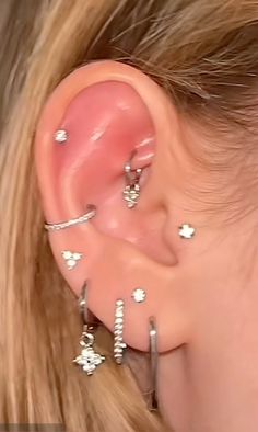 a close up of a person's ear with multiple piercings on the side