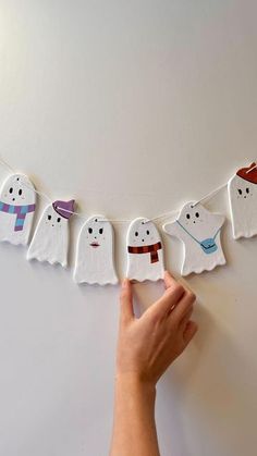 someone is holding up some paper ghost garlands to make it look like they are hanging on the wall