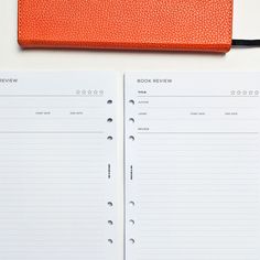 an orange notebook sitting on top of a white table