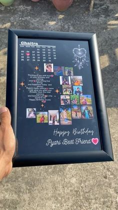 a person holding up a framed birthday card