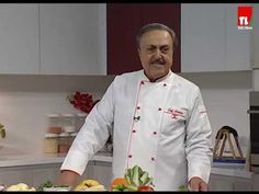 a man in a chef's outfit standing next to a cutting board with vegetables on it