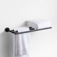 a towel rack with two towels hanging from it's sides and one folded white towel on the other side