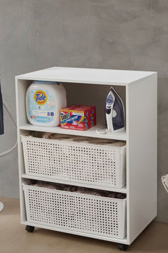 an ironing board next to a white cabinet with laundry products on it and a bottle of detergent