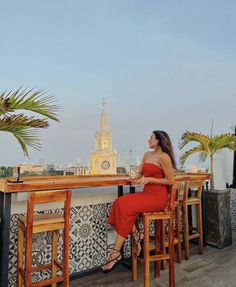 a woman in a red dress sitting at a bar