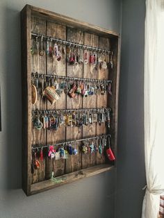 a wall mounted jewelry rack with several pairs of earrings hanging on it's sides