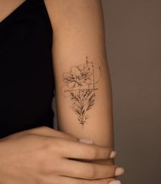 a woman's arm with a tattoo on it that has flowers in the middle