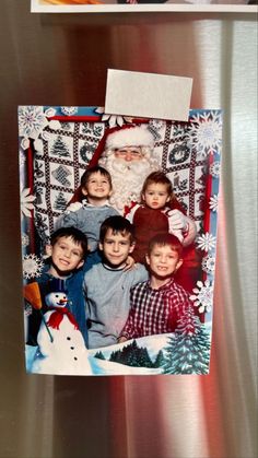 an old photo of children and santa clause on a refrigerator door with magnets attached to it