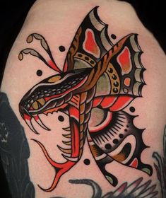 a colorful tattoo design on the back of a woman's shoulder and arm, with an intricate butterfly