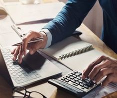 two people sitting at a table with notebooks and calculator in front of them