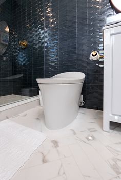 a white toilet sitting inside of a bathroom next to a shower