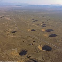 an aerial view of the desert with many mounds