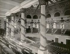 an old black and white photo of the inside of a building with columns, pillars and seats