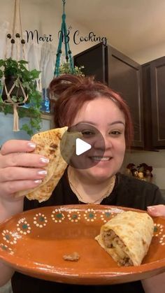 a woman holding a plate with some food on it