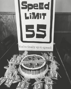 a speed limit 55 sign sitting on top of a table next to a cake and candies