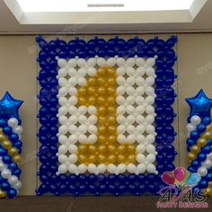 balloon art with the letter d in gold, white and blue colors on display at a party