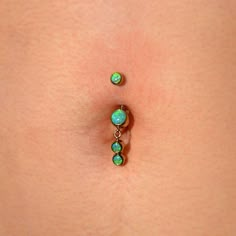 a close up of a person's belly with green beads