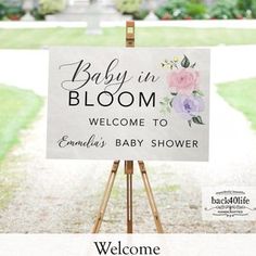 a baby in bloom welcome sign on an easel