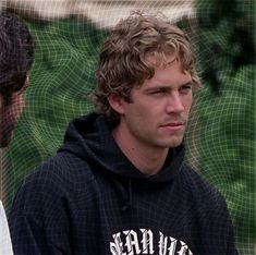 a man with curly hair wearing a black hoodie