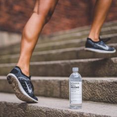 a bottle of water sitting on the steps next to someone's feet