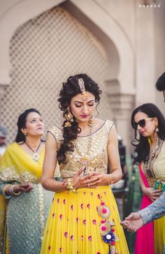 a woman in a yellow dress standing next to other women