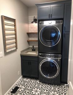 a washer and dryer in a small room with tile flooring on the walls