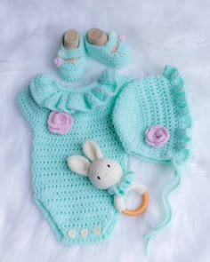 a crocheted baby outfit and booties are laying on a white furnishing