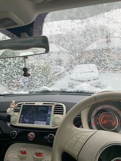 the dashboard of a car with snow on the mountains in the background