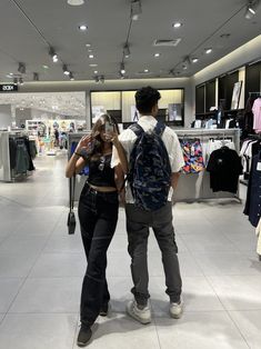 a man and woman taking pictures in a clothing store