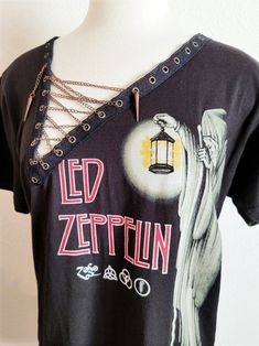 "Led Zeppelin Lace Up with Chain Asymmetrical Trim T-Shirt - Rock Band Concert T-Shirt - Copper Chain Each piece is uniquely designed and one of its' kind. Hand stitched edge detailing for superior quality and unique finish. Please note, since this is a handmade item, there may be slight variances with each T. UNISEX Sizing (women may choose to size down depending on fit preference) Appx. Measurements Laying Flat: S: 17\" across chest Width x 28\" Length M: 19\" across chest Width x 29\" Length Diy Concert Shirt, Primitive Clothing, T Shirt Reconstruction, Shirt With Chains, Cut Shirt Designs, Diy Cut Shirts, Led Zeppelin T Shirt, Cut Tee Shirts, Clothing Upcycle