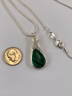 "This Malachite necklace is simple yet elegant. Malachite is a beautiful green color with unique striping/bands of color. I chose to enhance this beautiful smooth stone with a Celtic inspired silver wire design to let the natural beauty of the gemstone shine. This necklace is handmade by me with a synthetic malachite stone The necklace you will receive will be similar to the one in the picture, each stone is unique. The 4th photo in my listing shows the subtle variations of these Beautiful genui Green Wire Wrapped Necklace, Adjustable Green Sterling Silver Necklace, Green Malachite Necklace For Gift, Green Wire Wrapped Adjustable Necklace, Adjustable Green Teardrop Jewelry, Green Malachite Necklace For May Birthstone, Green Adjustable Teardrop Jewelry, Adjustable Green Wire Wrapped Necklace, Adjustable Teardrop Green Jewelry