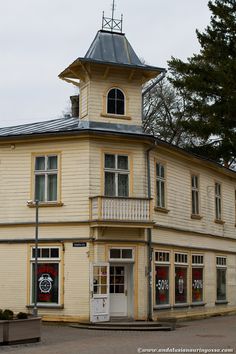 an old yellow building with a clock tower on the top and two doors in front