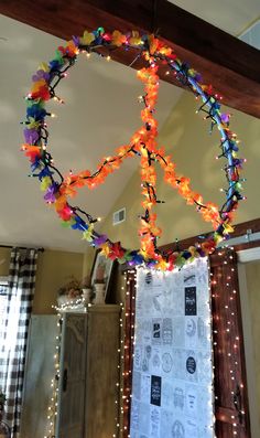 a peace sign hanging from the ceiling in a room with lights and decorations on it