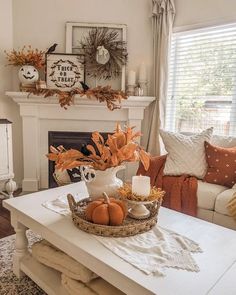 a living room filled with furniture and a fire place covered in pumpkins on top of a table