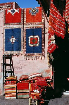 colorful carpets and rugs on display in front of a building