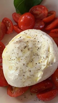 an egg and tomatoes on a white plate