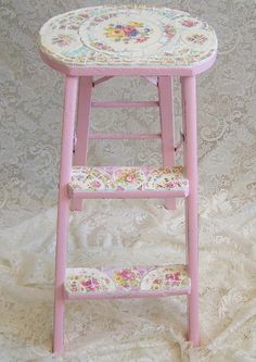 a pink step stool with floral designs on it