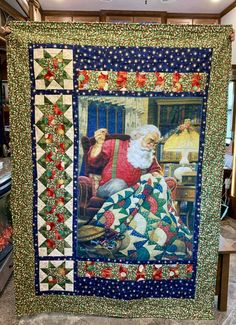 a quilted christmas scene with santa sitting on a chair in front of a fireplace