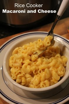 a white bowl filled with macaroni and cheese on top of a wooden table