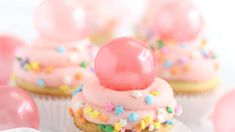 some cupcakes with pink frosting and sprinkles on top are shown