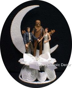 a cake topper with the image of two people standing on a moon and holding hands