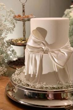 a white wedding cake with a bow on top