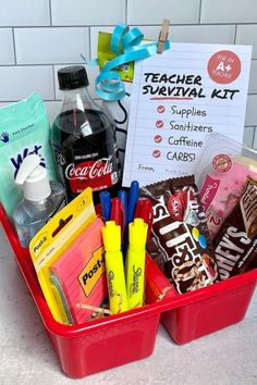 a red container filled with school supplies on top of a counter next to a sign that says teacher survival kit