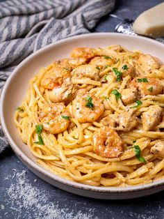 a plate of pasta with shrimp and parmesan cheese