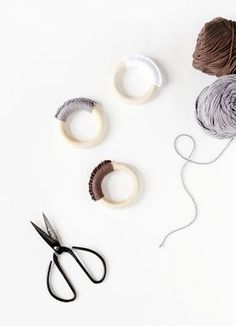 yarn, scissors and thread laid out on a white surface