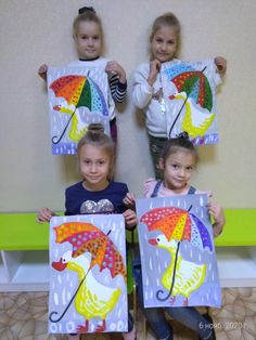 three girls holding up paintings with umbrellas on them